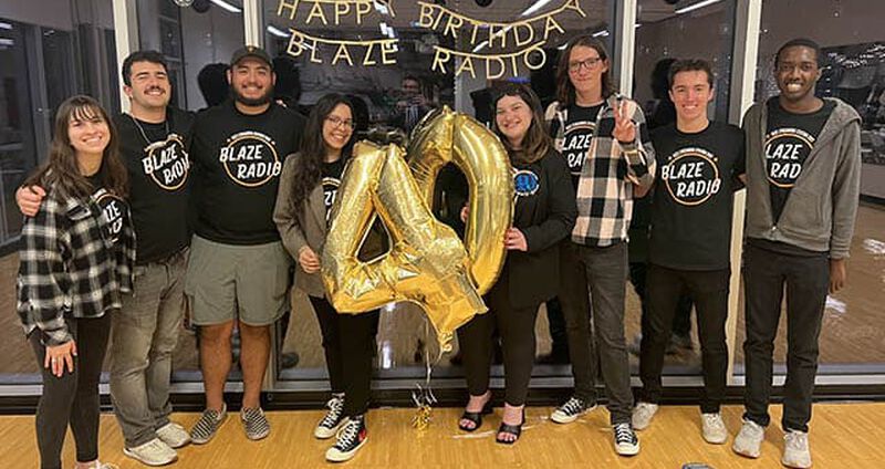 A group of students celebrate the 40th anniversary of Blaze Radio